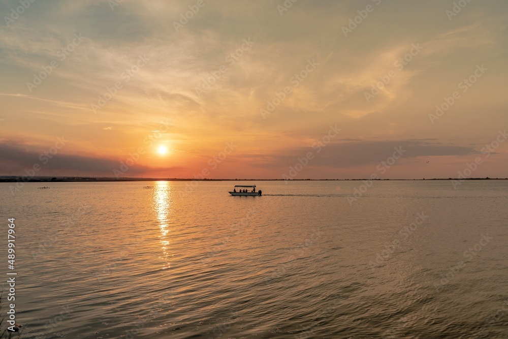Beautiful landscape with boat in the middle of the lake during sunset