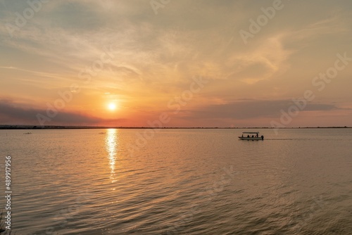 Beautiful landscape with boat in the middle of the lake during sunset