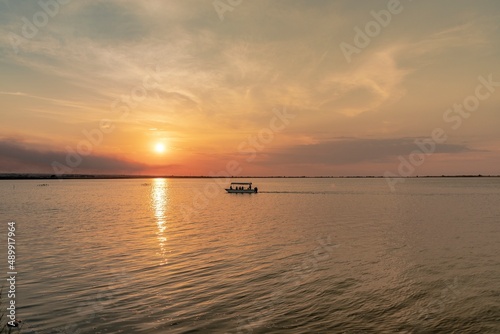Beautiful landscape with boat in the middle of the lake during sunset © giadophoto