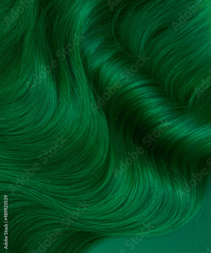 Unusual bright green natural hair colored with pigments. Beauty salon background for stories.