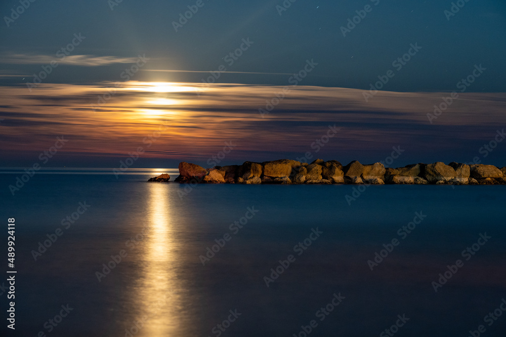 Fototapeta premium alba di luna sul mare adriatico con scogliera