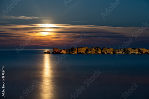 alba di luna sul mare adriatico con scogliera