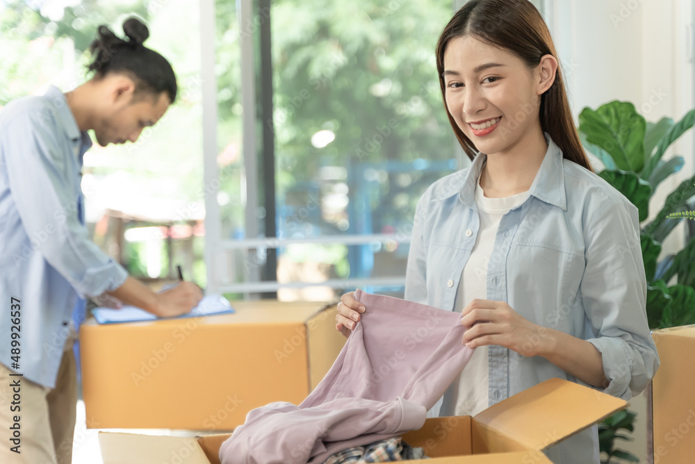 Asian couple checking the list of stuff before packing to cardboard for relocation move out of apartment. Asian couple checking the list of stuff before packing to cardboard for relocation move out of apartment.