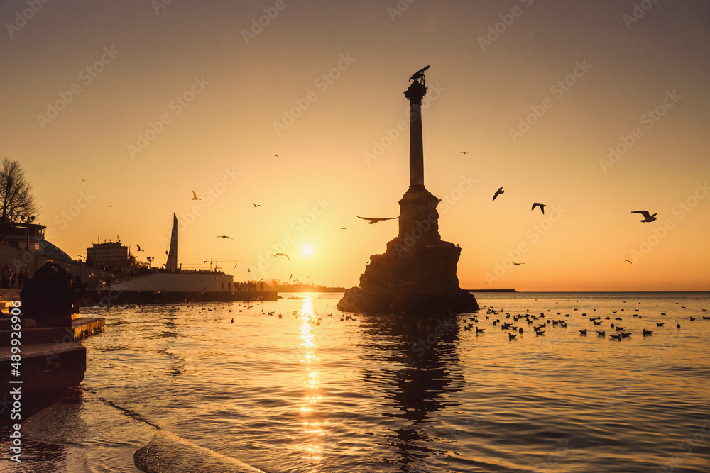 Sunset on embankment of Sevastopol. Monument to sunken ships against the sun. Sevastopol, Crimea