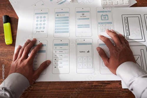 UX designer checking mock-ups of moble application interface he created photo