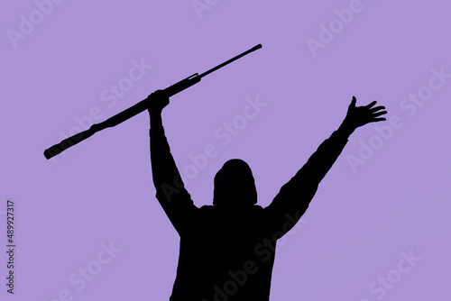 Silhouette of a man with a weapon in his hands against the background of art, lilac sky, the color of the year 2022. The concept of military operations, conflict resolution. Copyspace.