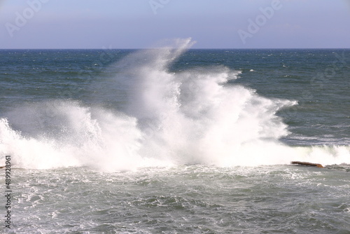Beautiful waves striking a wall and throwing spray into the wind.