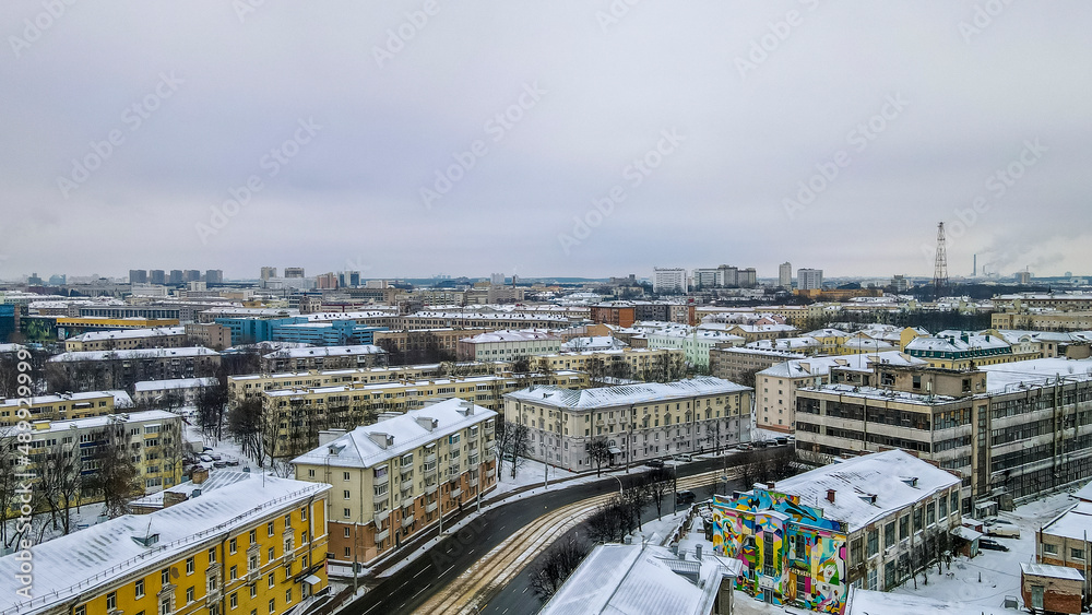 Aerial view of houses and road in the large city. Winter landscape. Residential areas in central of Minsk in the snow.