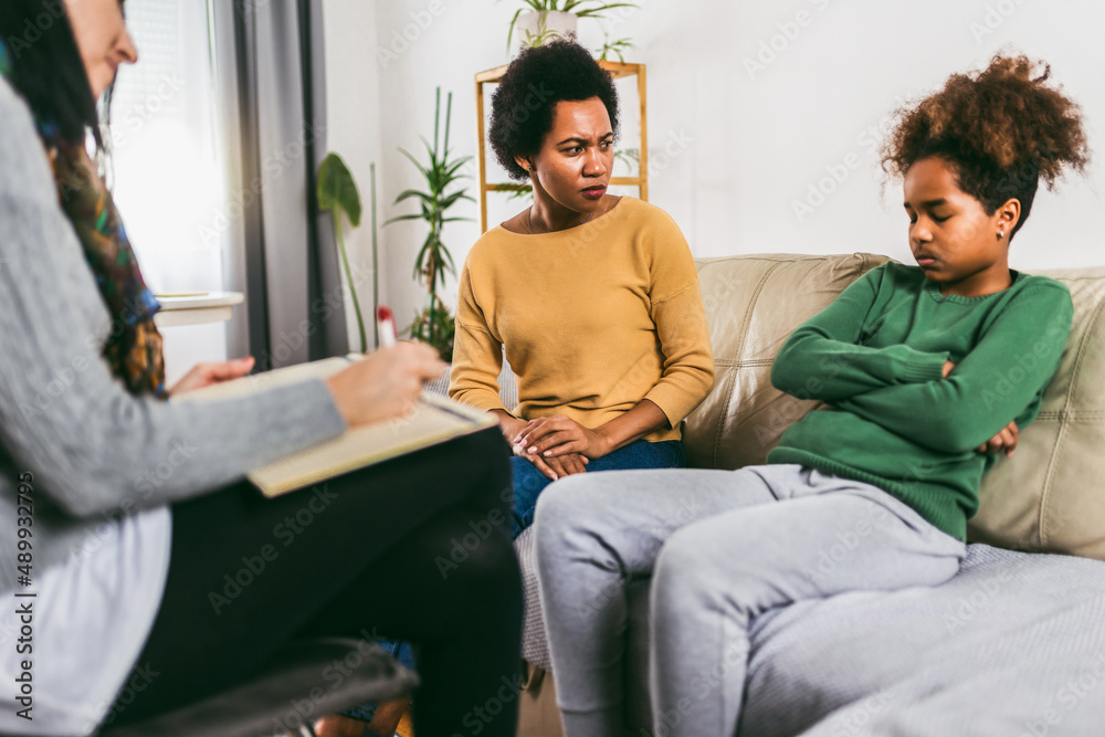 Mother and her teenager daughter talking with therapist.