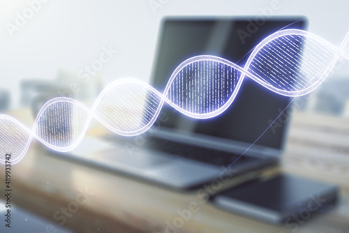 Creative concept with DNA symbol illustration and modern desktop with computer on background. Genome research concept. Multiexposure