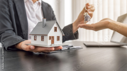 Billede på lærred Real estate agent holding a key and asking costumer for contract to buy, get insurance or loan real estate or property