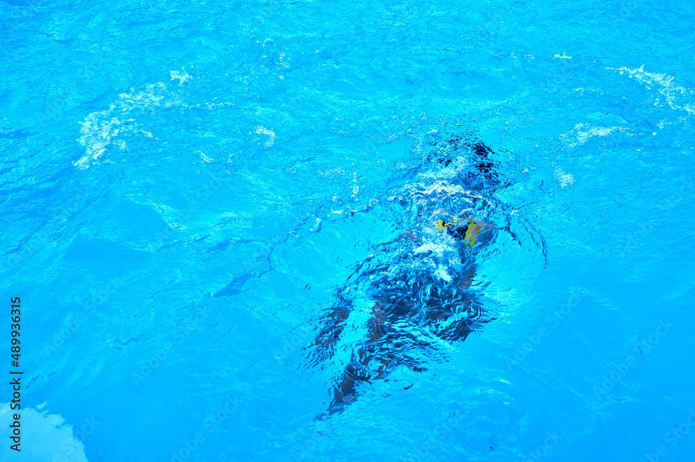 silhouette of a person under the water of a swimming pool