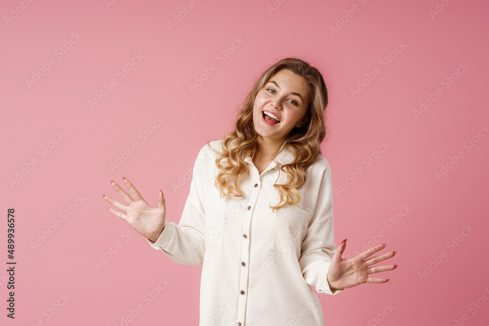 Portrait of a happy girl with long blonde hair, smiling and rejoicing. A teenager, emotionally excited with delight, looks into the camera, standing on a pink background in the studio Portrait of a happy girl with long blonde hair, smiling and rejoicing. A teenager, emotionally excited with delight, looks into the camera, standing on a pink background in the studio
