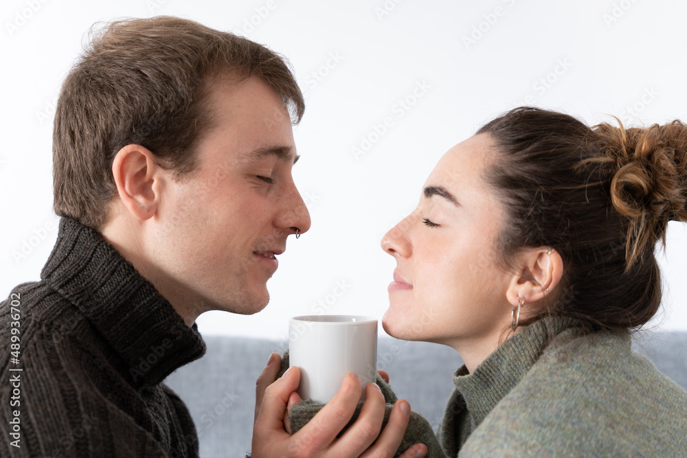 Romantic couple smelling and holding a warm cup of coffee Romantic couple smelling and holding a warm cup of coffee