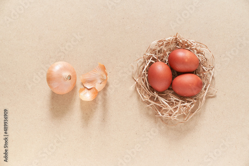 Close-up of the nest in which there are Easter eggs on a sandy background. The concept of painting eggs with onion husks. Top view. With space to copy. High quality photo photo