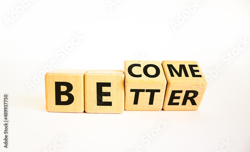 Become better symbol. Turned wooden cubes and changed the concept word Better to Become. Beautiful white table white background. Business become better concept. Copy space.