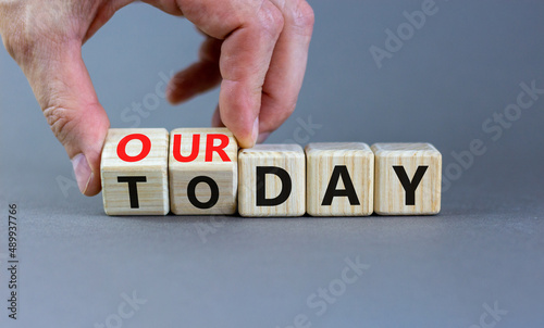 Today is our day symbol. Businessman turns wooden cubes and changes concept words Today to our day. Beautiful grey table grey background, copy space. Business, motivation today is our day concept.