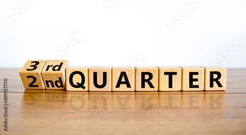 From 2nd second to third 3rd quarter symbol. Turned wooden cubes and changed words 2nd quarter to 3rd quarter. Beautiful wooden table white background. Business happy 3rd quarter concept. Copy space. photo