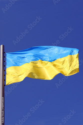 yellow-blue national flag of ukraine flutters against the blue sky close-up