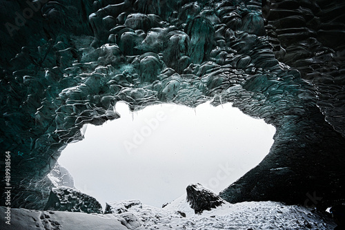 Oval Entry to Turquoise Glacial Cave with Snowy Rock Floor in Iceland photo