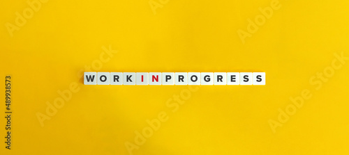 Obraz na plátne Work In Progress Expression on Letter Tiles on Yellow Background