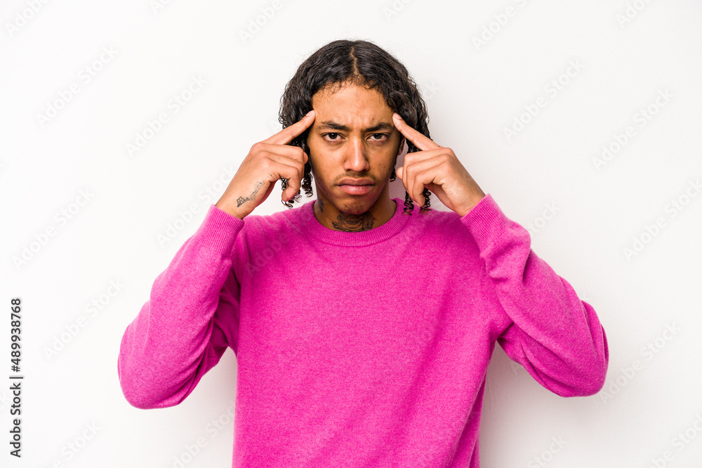 Fototapeta premium Young African American man isolated on white background focused on a task, keeping forefingers pointing head.