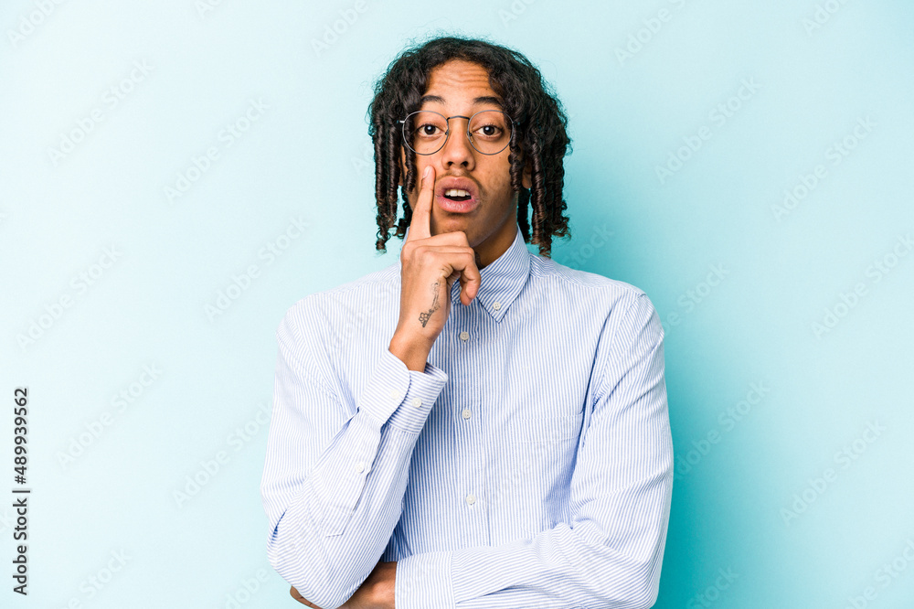 Young African American man isolated on blue background having some great idea, concept of creativity. Young African American man isolated on blue background having some great idea, concept of creativity.