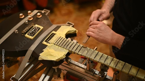 Guitar in repair service shop with a hands of a guitar luthier