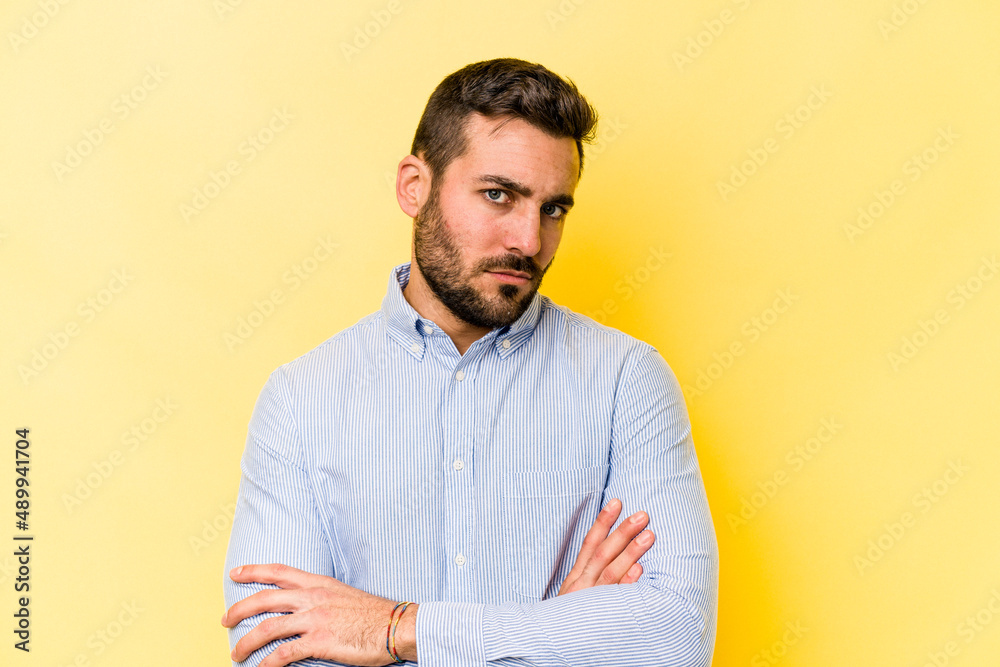 Young caucasian man isolated on yellow background who is bored, fatigued and need a relax day. Young caucasian man isolated on yellow background who is bored, fatigued and need a relax day.