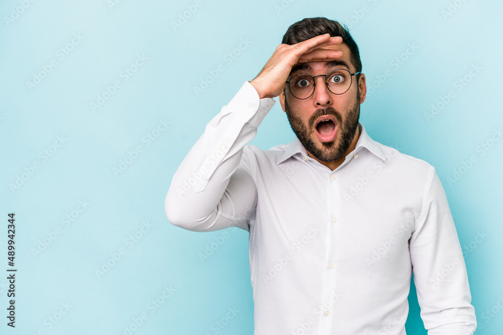 Young caucasian man isolated on blue background looking far away keeping hand on forehead. Young caucasian man isolated on blue background looking far away keeping hand on forehead.