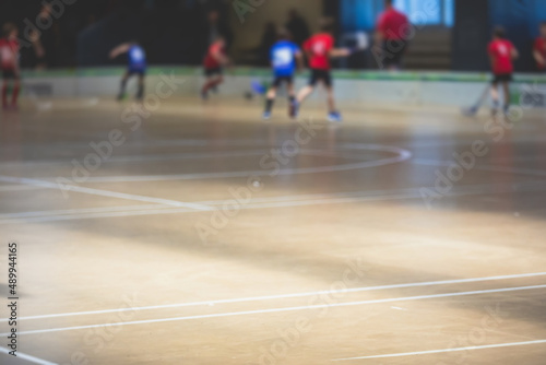 View of floorball match game, court hall indoor venue with junior teenage children school team playing in the background, floor ball hockey match game on arena stadium, copy space © tsuguliev