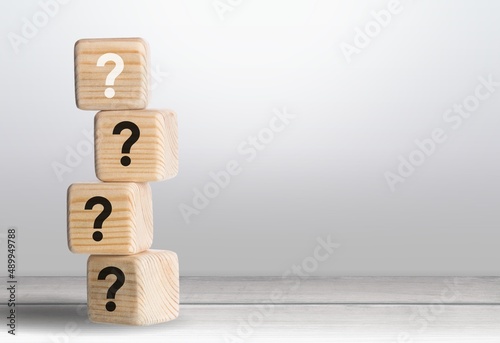 Wooden cube block with question mark mean what on table background