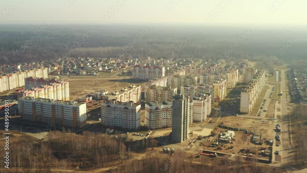 Construction Crane Is Involved In Construction Of A New Multi-storey Residential Houses. Aerial View Of Multistory Houses. Real Estate High-rise Buildings. Development Industry.