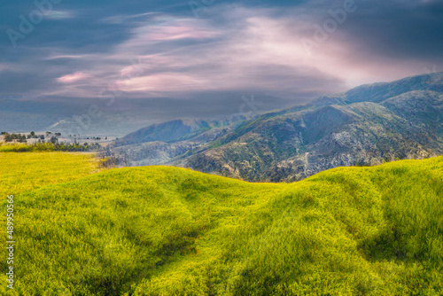 Landscape with mountains and clouds.  Green foreground.