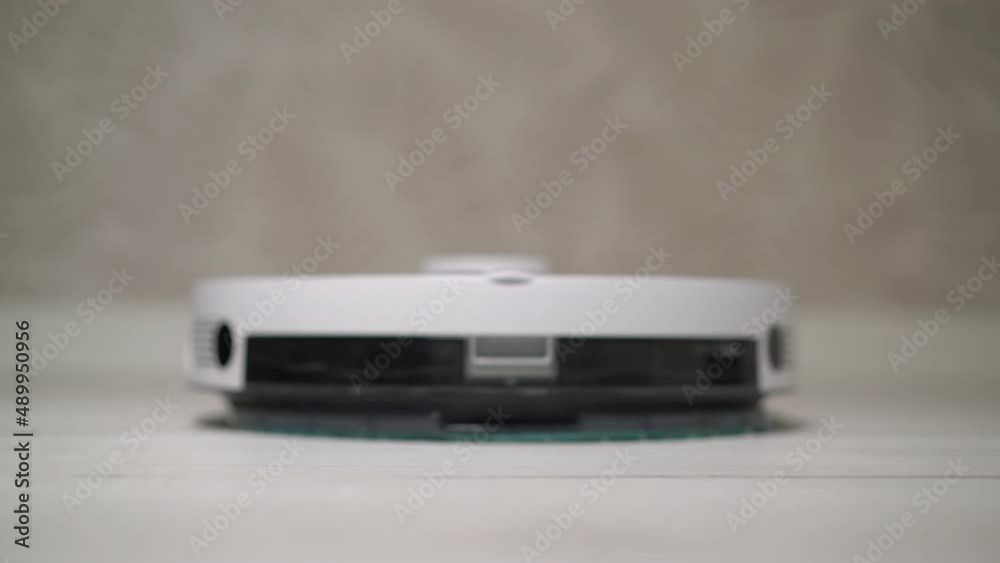 Automatic robot vacuum cleaner cleaning the room. Charging dock station. Automatic robot vacuum cleaner cleaning the room. Charging dock station.