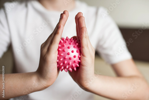 self-massage of hands with a ball with spikes