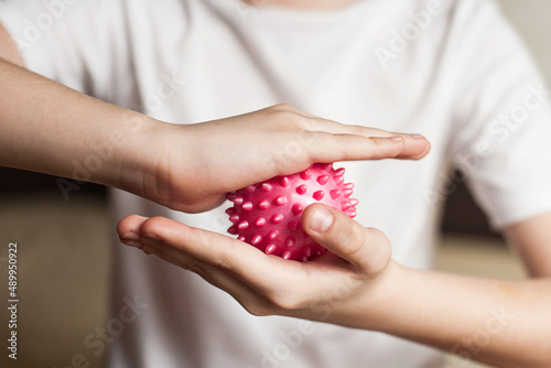 self-massage of hands with a ball with spikes