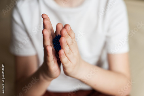 self-massage of hands with a ball with spikes