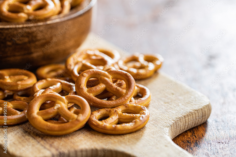 Mini pretzels. Crusty salted snack on cutting board. Mini pretzels. Crusty salted snack on cutting board.