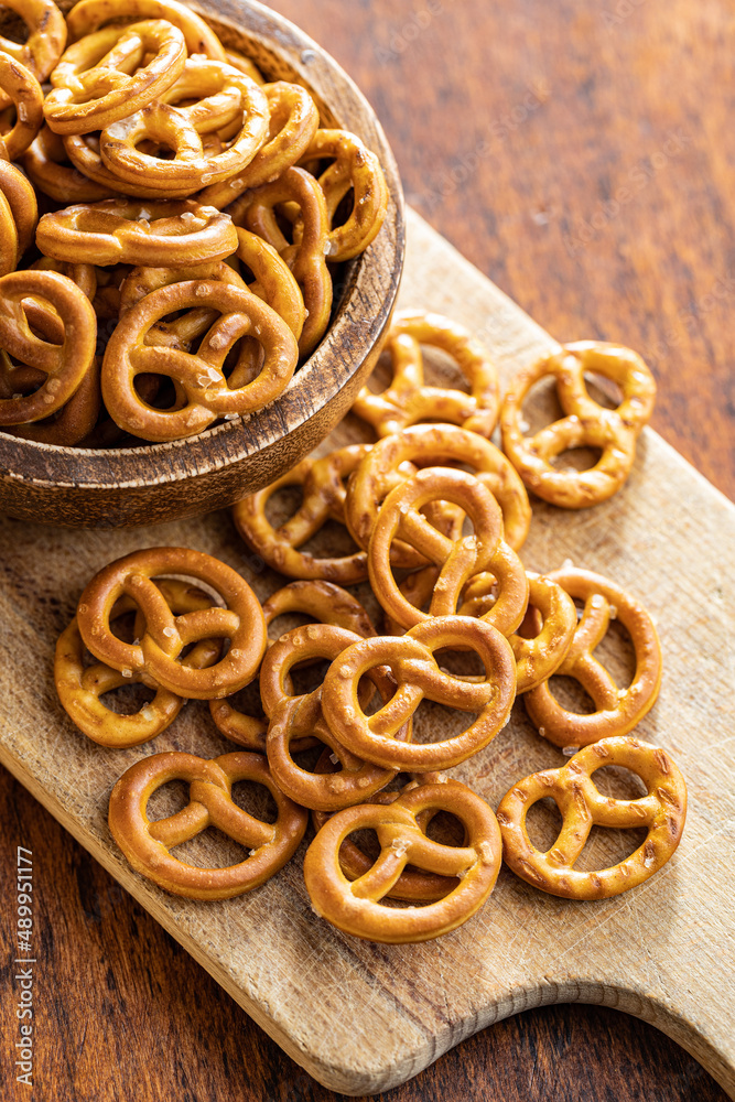 Mini pretzels. Crusty salted snack on cutting board. Mini pretzels. Crusty salted snack on cutting board.