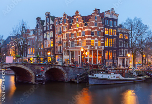 Fototapeta Naklejka Na Ścianę i Meble -  Beautiful old houses on the city waterfront of Amsterdam at sunset.