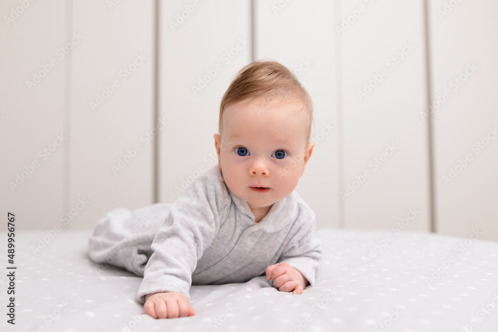 Portrait of cute smiling happy baby boy crawling on bed on the white blanket in bedroom. Portrait of cute smiling happy baby boy crawling on bed on the white blanket in bedroom.