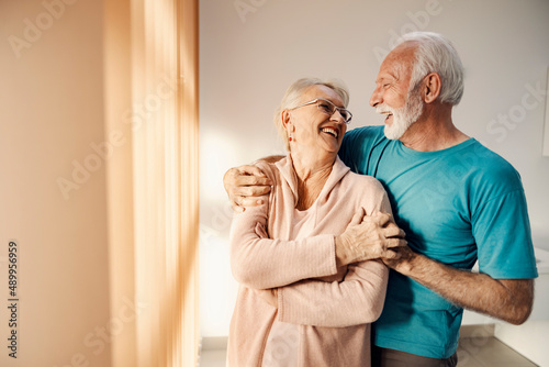 фотографія A happy senior couple hugging and laughing at nursing home.