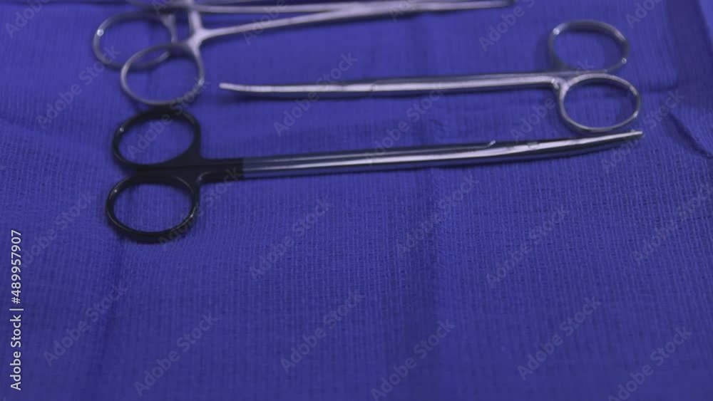 Surgical Instruments on Tray Close Up Move Overhead. sanitized surgical instruments on a tray with blue cloth for operation moving overhead towards close up Surgical Instruments on Tray Close Up Move Overhead. sanitized surgical instruments on a tray with blue cloth for operation moving overhead towards close up