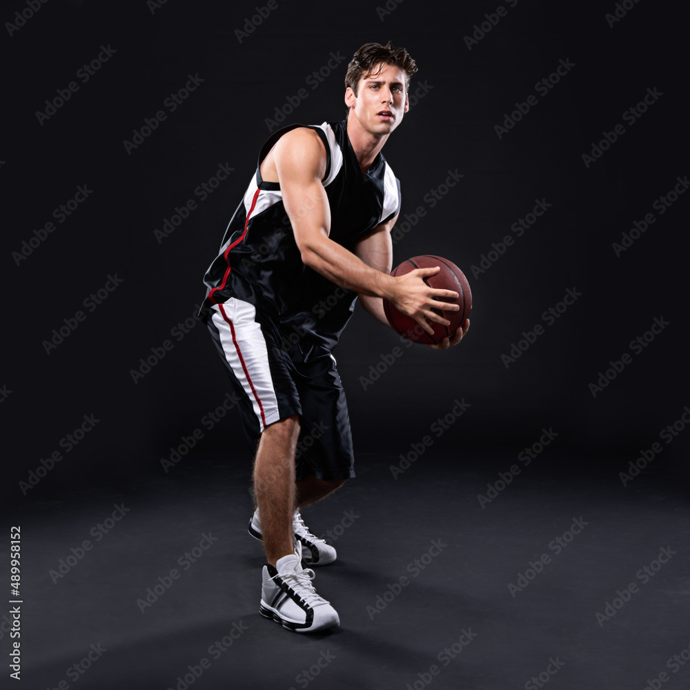 Winning isnt everything but the will to win is. Full length studio shot of a young male basketball player in action against a black background. Winning isnt everything but the will to win is. Full length studio shot of a young male basketball player in action against a black background.