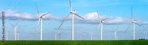 Panoramic view of a large field of wind turbines in operation.