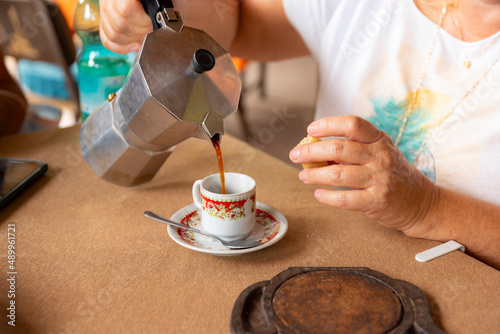 woman drinking a cup of traditional coffee on a coffee plantation