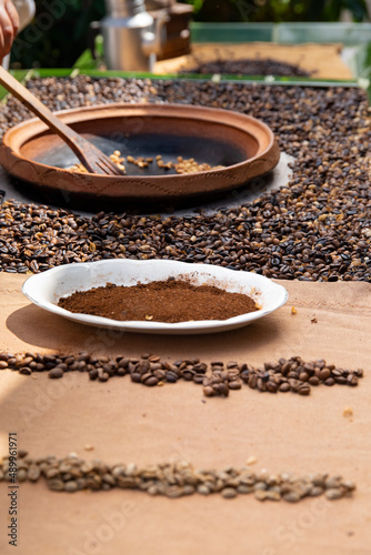 traditional roasting of coffee beans in a clay bowl, roasted beans and green beans