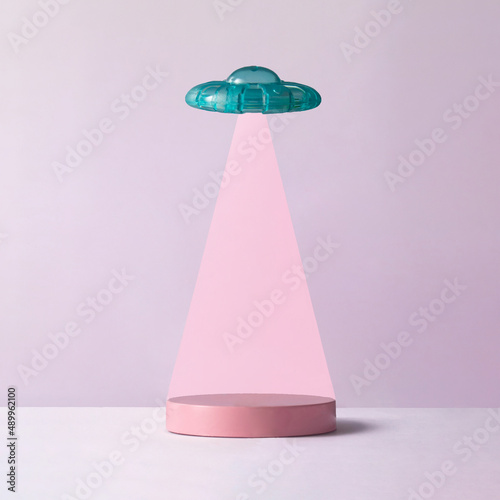Place for product below UFO on pastel light purple background. Creative fantasy concept with copy space.