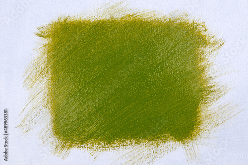 wide brush stroke with saturated bright light olive-green paint on a white background, close up